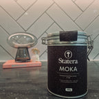 Statera Moka canister on a kitchen counter with a tiled wall background